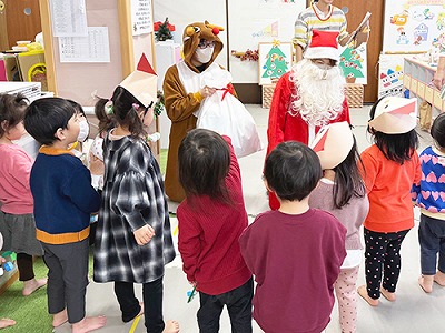サンタさんからクリスマスプレゼントをもらう子どもたち