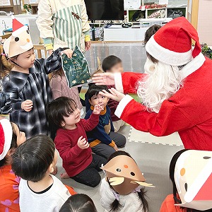 サンタさんからクリスマスプレゼントをもらう子どもたち