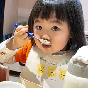 スプーンで給食を口に運ぶ子ども