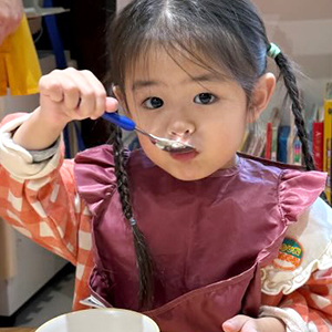 スプーンで給食を口に運ぶ子ども