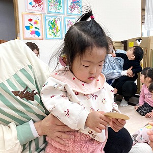 お賽銭を持ってみつめる子ども