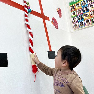 ほほえみ神社の鈴紐を鳴らす子ども