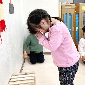 賽銭箱の前で手を合わせる子ども