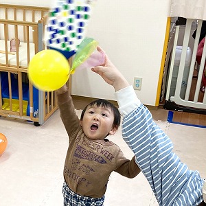 風船羽根つきをしてはしゃぐ子どもたち