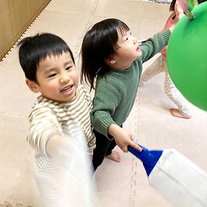 風船羽根つきをしてはしゃぐ子どもたち