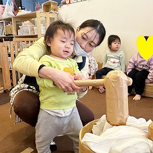 餅つきあそびを楽しむ子どもと保育士
