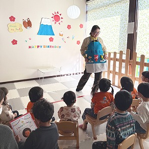 保育士によるエプロンシアターを見つめる子どもたち