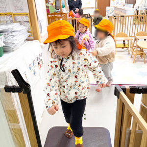 防災用帽子を被って避難をする子どもたち