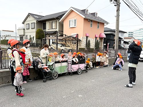 避難訓練で屋外に集まる子どもたちと保育士
