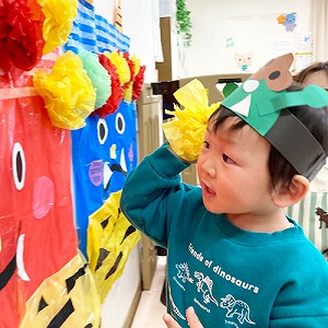 鬼の顔に髪の毛を飾り付けする子ども