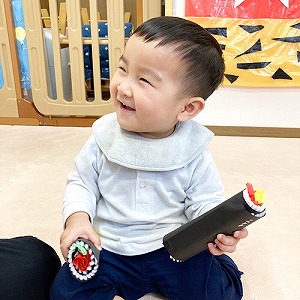 両手に恵方巻を持って笑う子ども