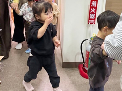 口に手を当てて避難訓練をする子どもたち