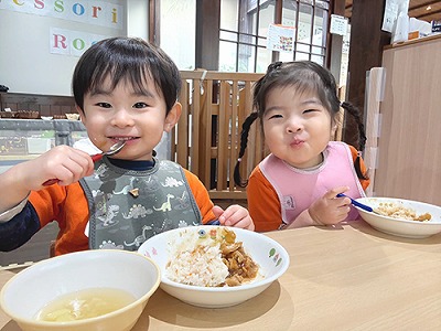 給食を笑顔で頬張る子どもたち