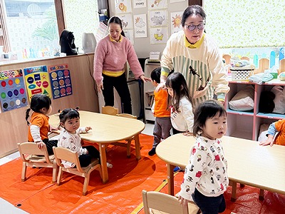 避難訓練を開始する保育士と子どもたち