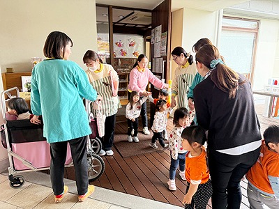 保育士と手をつないで避難をする子どもたち