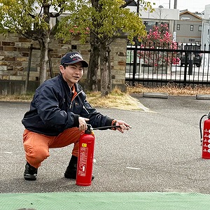 消火器を手にしながら話しをする消防士