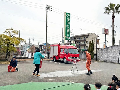 消防士の指導の下、消火器の使い方を練習する保育士