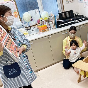 子どもたちにスケッチブックシアターを披露する保育士