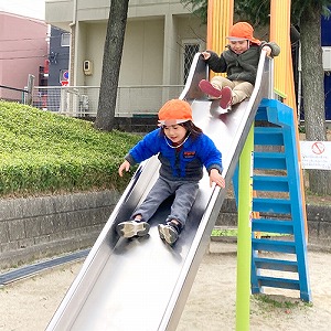 滑り台を滑り降りる子どもたち