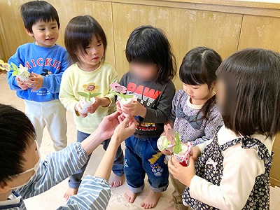 先生から写真付きお花を受け取る卒園児たち