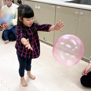 大きなピンク色のボールを投げる子ども