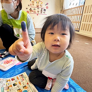 絵の具がついた人差指をみせる子ども