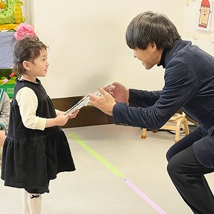 園長先生から色紙のプレゼントを受け取る卒園児