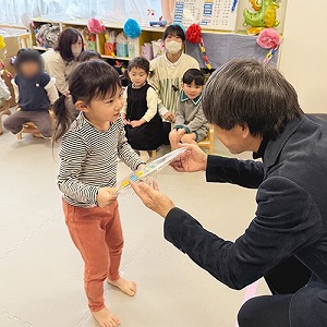園長先生から色紙のプレゼントを受け取る卒園児