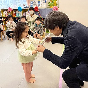 園長先生から色紙のプレゼントを受け取る卒園児