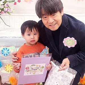 プレゼントの色紙も持つ卒園児と園長先生