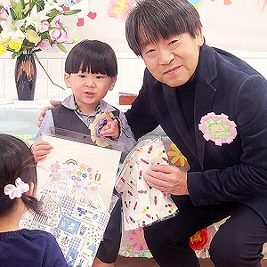 プレゼントの色紙も持つ卒園児と園長先生