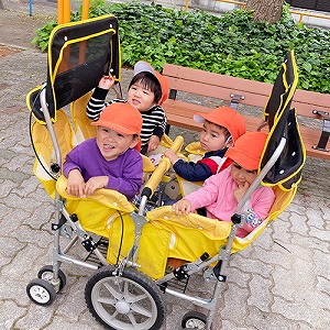 お散歩カートに乗って公園へ向かう子どもたち