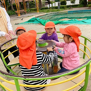 みんなで公園のコーヒーカップに乗る子どもたち