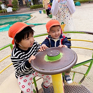 公園のコーヒーカップに乗る子どもたち