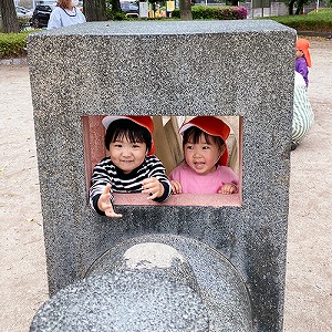 汽車の遊具の窓から笑顔を見せる子どもたち