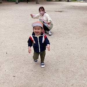 保育士が吹くシャボン玉を追いかける子ども