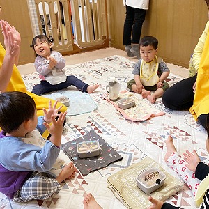 お弁当箱を前にいただきますと手をあわせる子どもたち