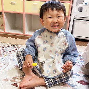 フォークを持って笑顔を見せる子ども