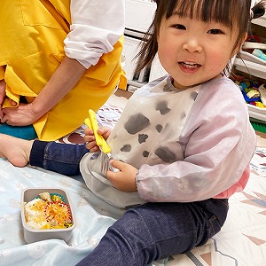 お弁当を食べる前に微笑む子ども