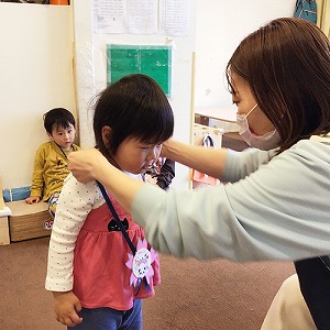 進級のメダルを掛けてもらう子ども