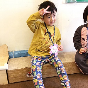 メダルを掛けてもらいピースサインをする子ども