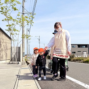 保育士と手を繋いでお散歩にでかける園児たち