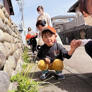 散歩への道中たんぽぽをみつける子ども