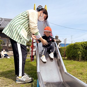 公園の滑り台をすべる子ども