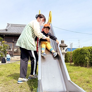 公園の滑り台をすべる子ども