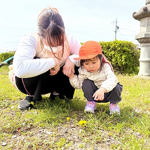 お花をみつめる子どもと保育士