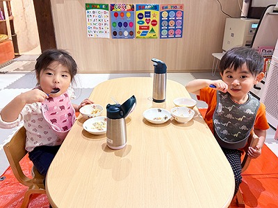 スプーンを給食を食べる子どもたち
