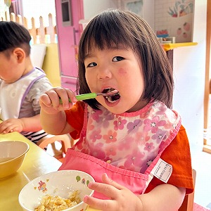 大きな口をあけて給食を食べる子ども