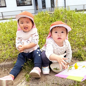 お花を摘んで笑顔を見せる子どもたち