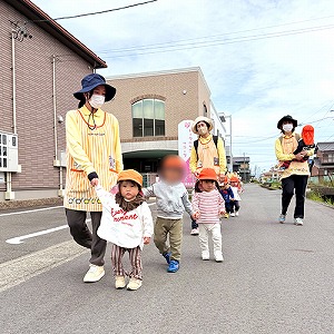 先生と手をつないで散歩にでかける子どもたち